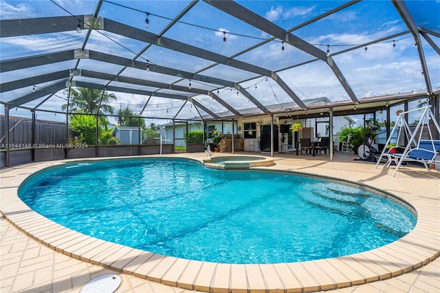 view of pool featuring an in ground hot tub, a patio, and a lanai