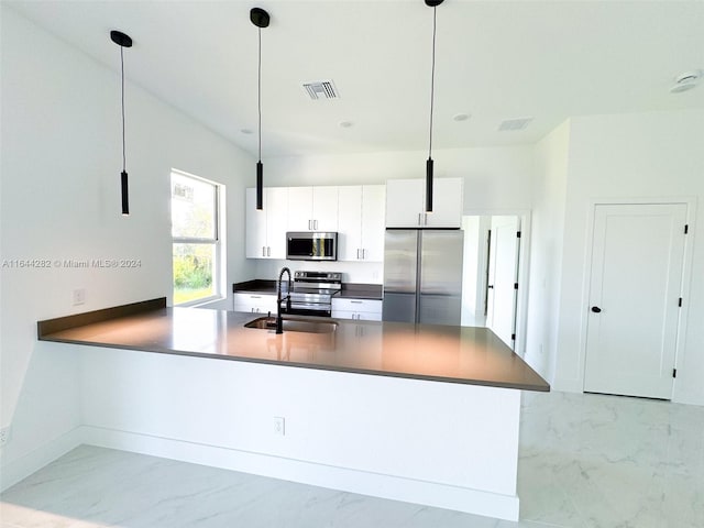 kitchen with stainless steel appliances, hanging light fixtures, white cabinetry, and sink