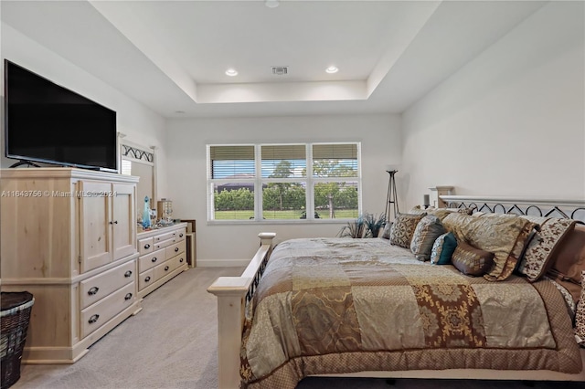 bedroom featuring visible vents, light carpet, a tray ceiling, recessed lighting, and baseboards