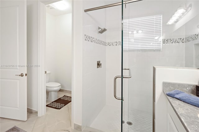 bathroom with vanity, a shower stall, and toilet