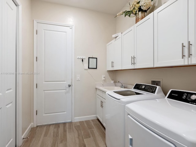 laundry area featuring cabinets, sink, washing machine and clothes dryer, and light wood-type flooring