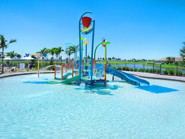 view of playground with a community pool and pool water feature