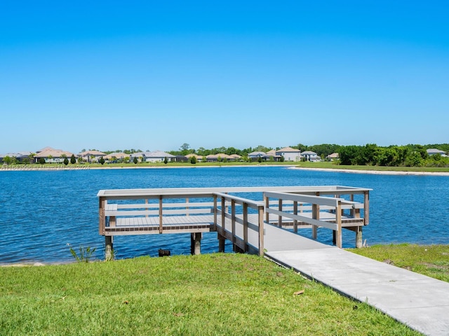 dock area featuring a water view and a lawn