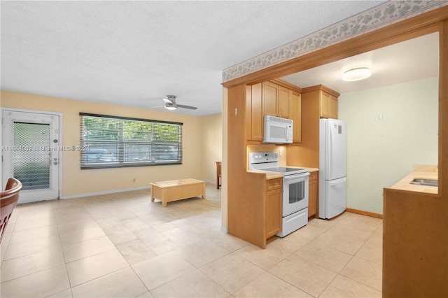 kitchen featuring a textured ceiling, white appliances, ceiling fan, and light tile patterned flooring