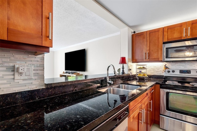 kitchen with tasteful backsplash, sink, dark stone countertops, crown molding, and stainless steel appliances