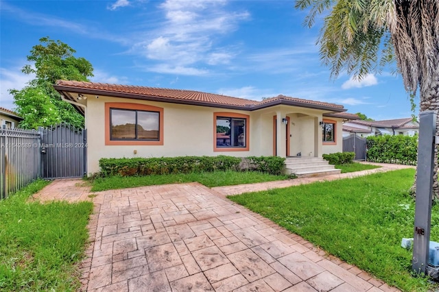 mediterranean / spanish house featuring a front lawn