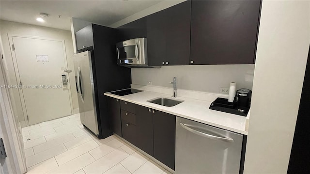 kitchen with sink, appliances with stainless steel finishes, dark brown cabinetry, and light tile patterned floors