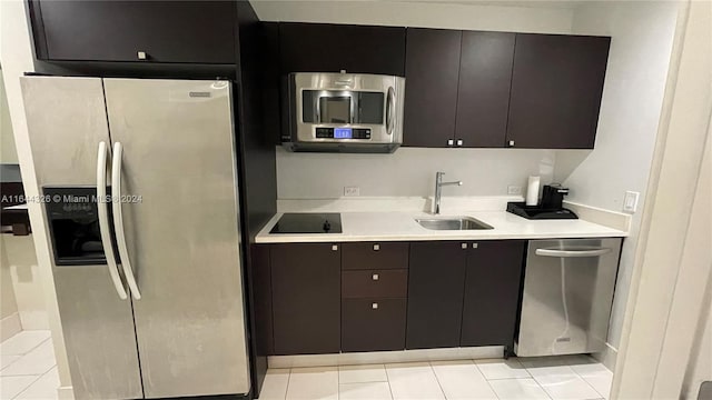 kitchen featuring light tile patterned floors, appliances with stainless steel finishes, sink, and dark brown cabinets