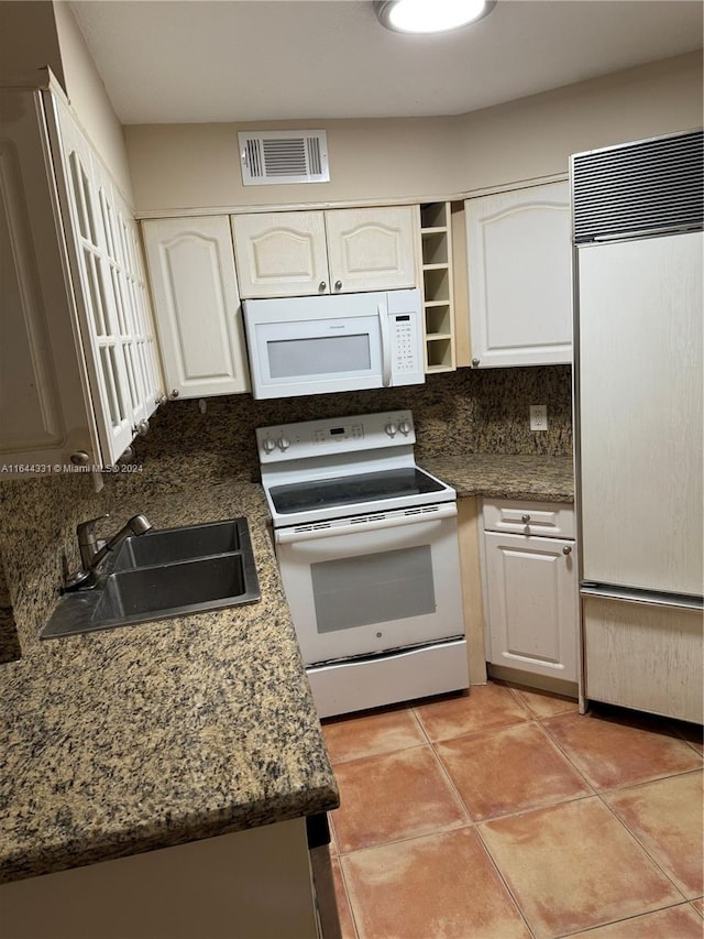 kitchen with visible vents, a sink, white cabinetry, white appliances, and light tile patterned floors