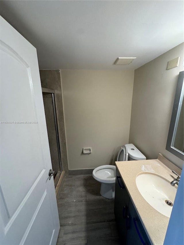 full bathroom featuring baseboards, toilet, a stall shower, and vanity