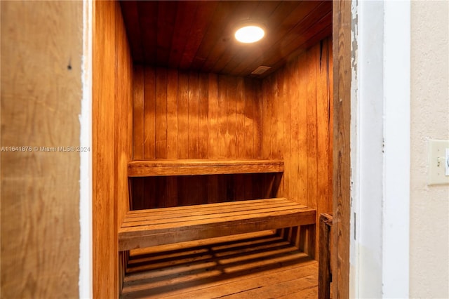 view of sauna / steam room featuring wood-type flooring, wood walls, and wooden ceiling