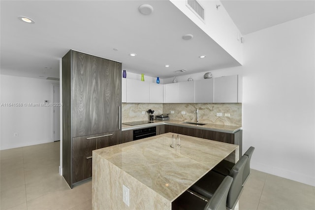 kitchen with a sink, visible vents, white cabinetry, a center island, and modern cabinets