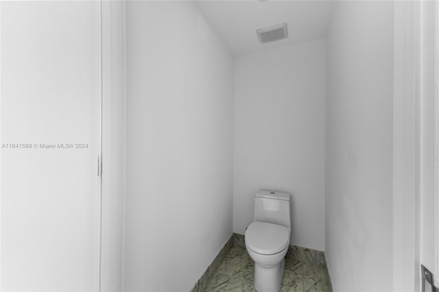 bathroom with toilet, marble finish floor, and visible vents