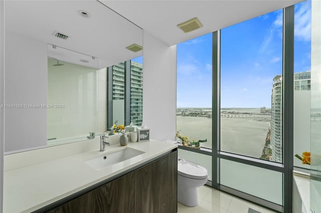 bathroom with toilet, a city view, vanity, visible vents, and expansive windows