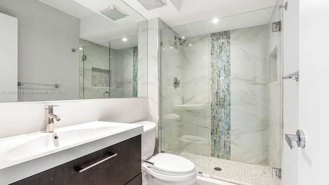 bathroom with walk in shower, vanity, and toilet