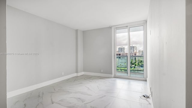 spare room featuring plenty of natural light and floor to ceiling windows