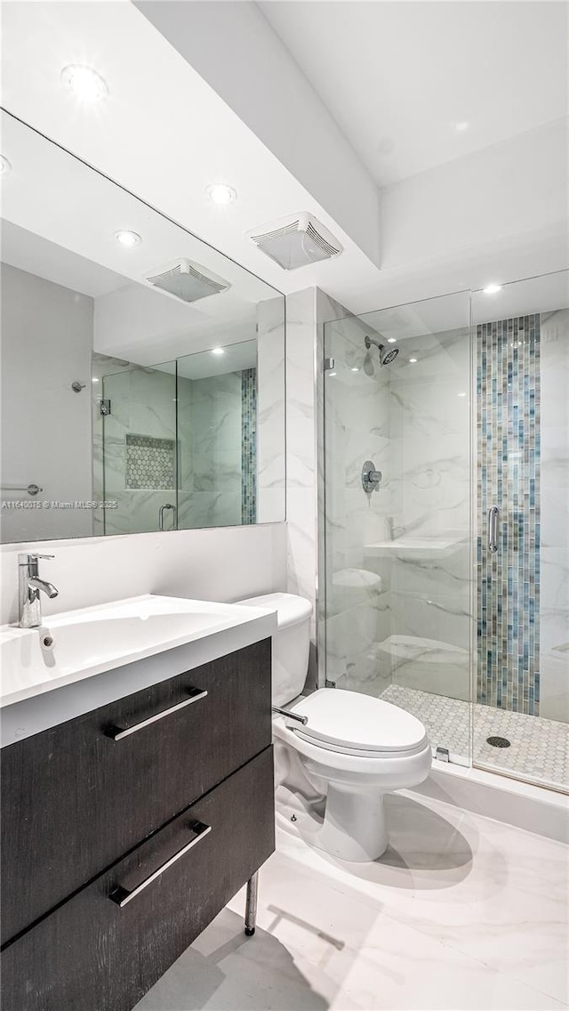 bathroom with vanity, toilet, and a shower with shower door