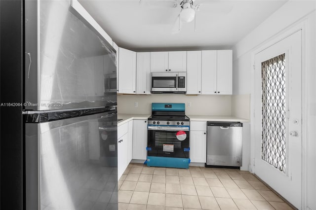 kitchen with appliances with stainless steel finishes, ceiling fan, white cabinetry, and light tile patterned floors