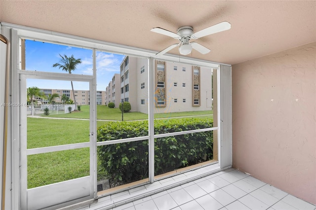 unfurnished sunroom featuring ceiling fan