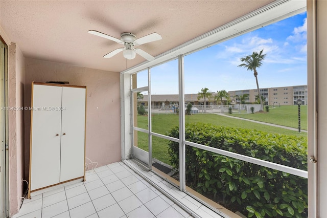 unfurnished sunroom with ceiling fan