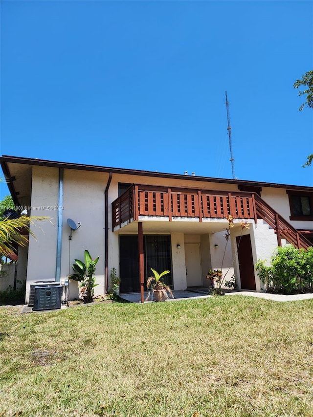 back of house with cooling unit and a yard