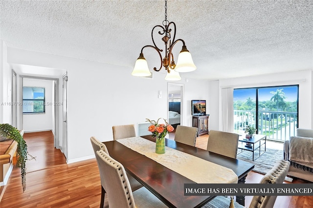 dining space featuring a textured ceiling, an inviting chandelier, and light hardwood / wood-style flooring