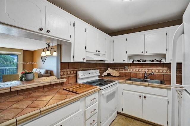 kitchen featuring backsplash, tile counters, white electric range, and sink