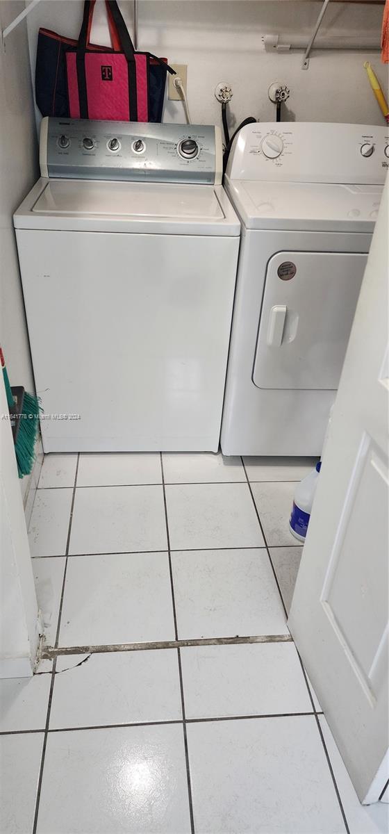 washroom with laundry area, tile patterned floors, and washer and clothes dryer