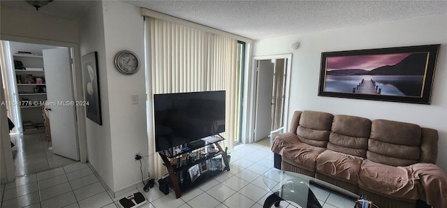 living area with tile patterned floors, a textured ceiling, and a wall of windows