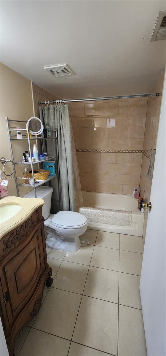 full bathroom with visible vents, toilet, vanity, and tile patterned flooring