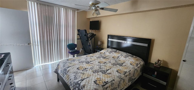 bedroom with a textured ceiling, tile patterned floors, and ceiling fan