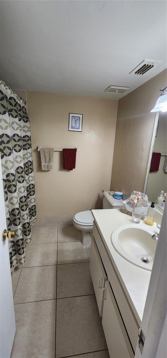 bathroom featuring vanity, tile patterned floors, toilet, and visible vents