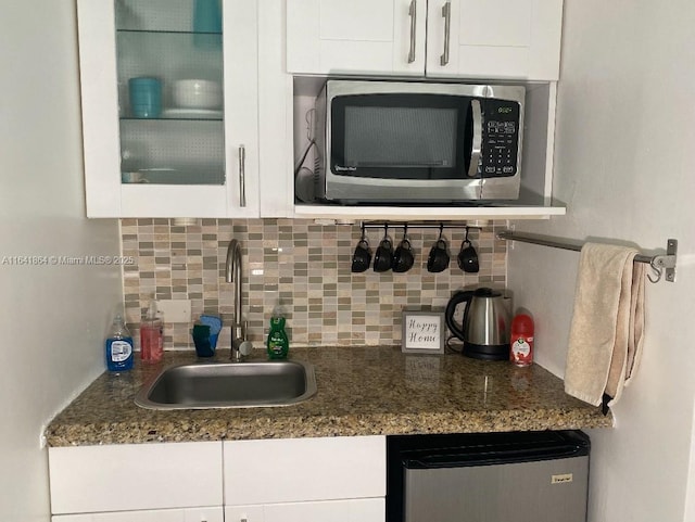 kitchen featuring tasteful backsplash, sink, and white cabinets