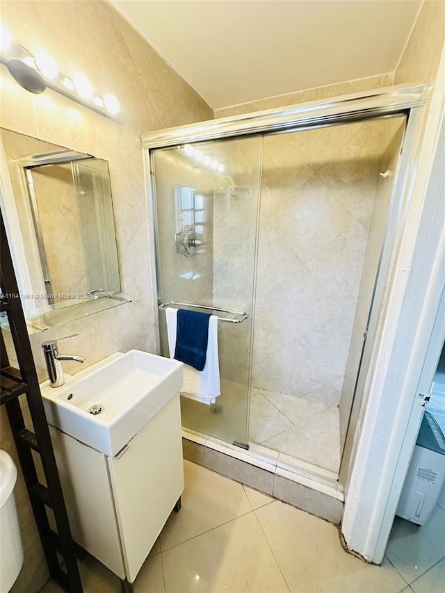 bathroom featuring tile walls, vanity, tile patterned floors, and an enclosed shower