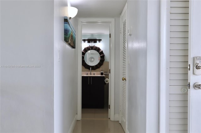 hall featuring sink and light tile patterned floors