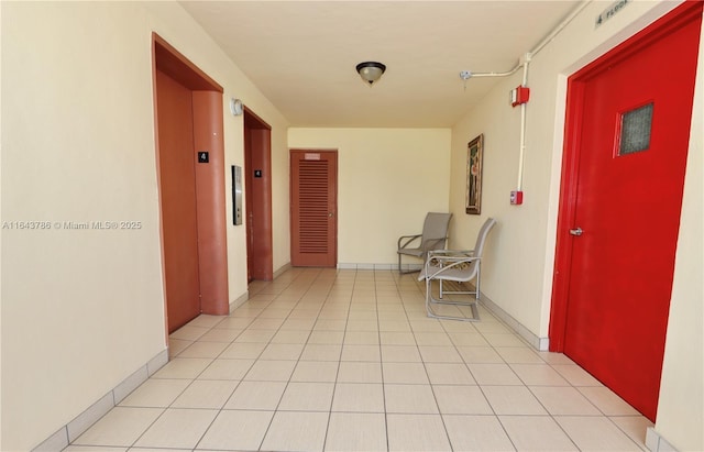 hall featuring elevator and light tile patterned floors