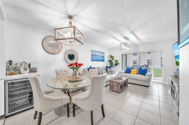 dining area featuring an inviting chandelier, wine cooler, indoor bar, a textured ceiling, and light tile patterned floors