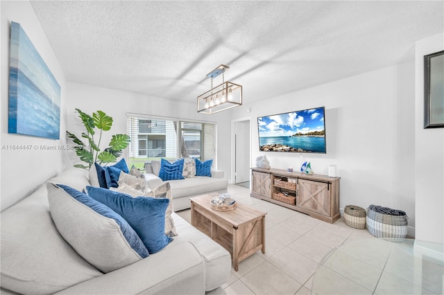 living room featuring tile patterned floors, a textured ceiling, and a notable chandelier