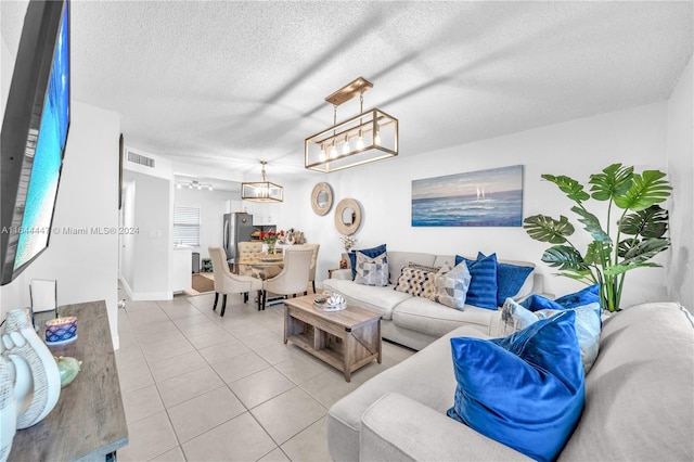 living room with light tile patterned flooring, a textured ceiling, and a chandelier