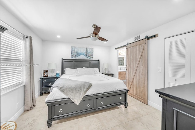 bedroom featuring a barn door and ceiling fan