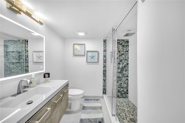 bathroom with vanity, an enclosed shower, and toilet