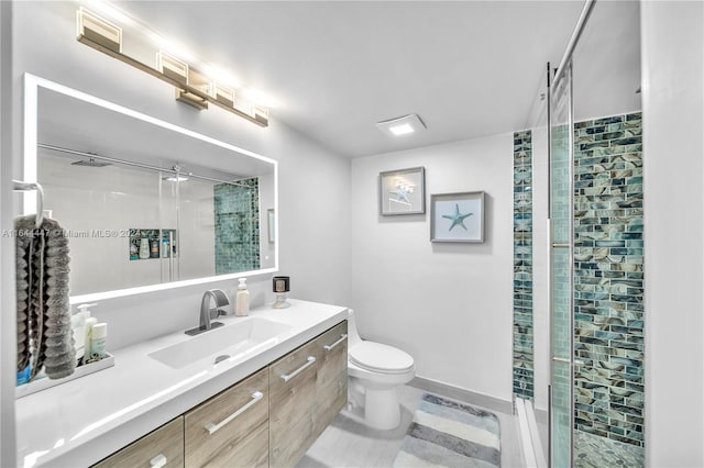 bathroom featuring vanity, toilet, and a shower with shower door