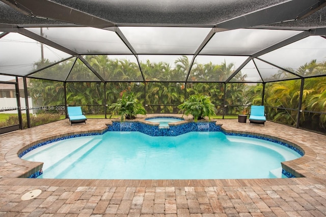 view of pool with an in ground hot tub, pool water feature, and glass enclosure