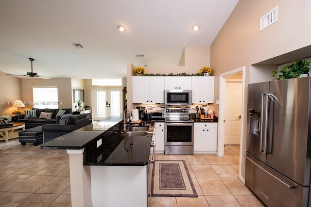 kitchen with appliances with stainless steel finishes, kitchen peninsula, sink, white cabinetry, and ceiling fan