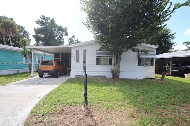 view of front facade featuring a carport, cooling unit, and a front lawn