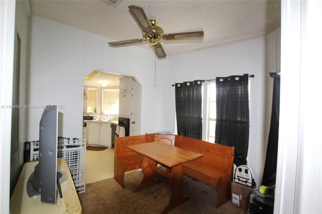 carpeted dining space with ceiling fan