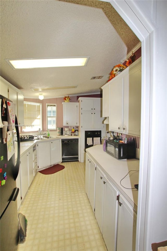 kitchen featuring white cabinetry, light tile patterned floors, sink, a textured ceiling, and black appliances