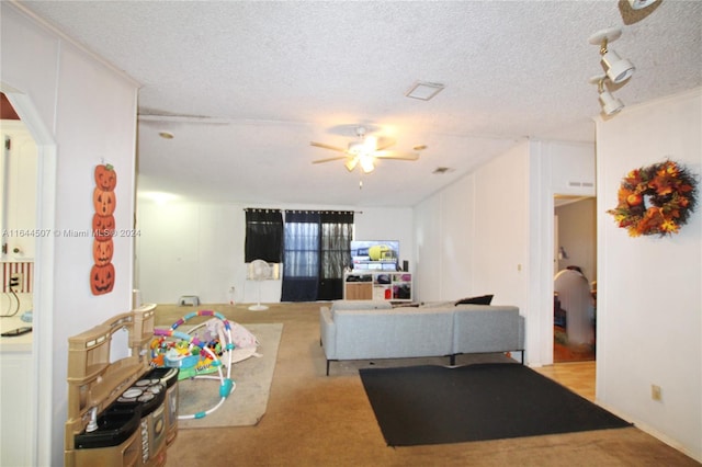 carpeted living room with ceiling fan, a textured ceiling, and track lighting