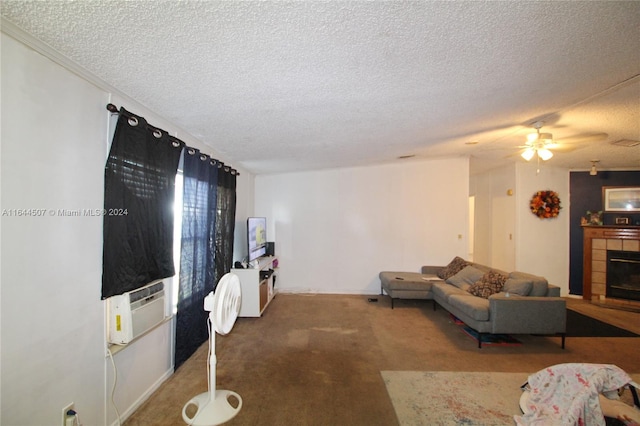 living room featuring ceiling fan, carpet, a tile fireplace, and a textured ceiling