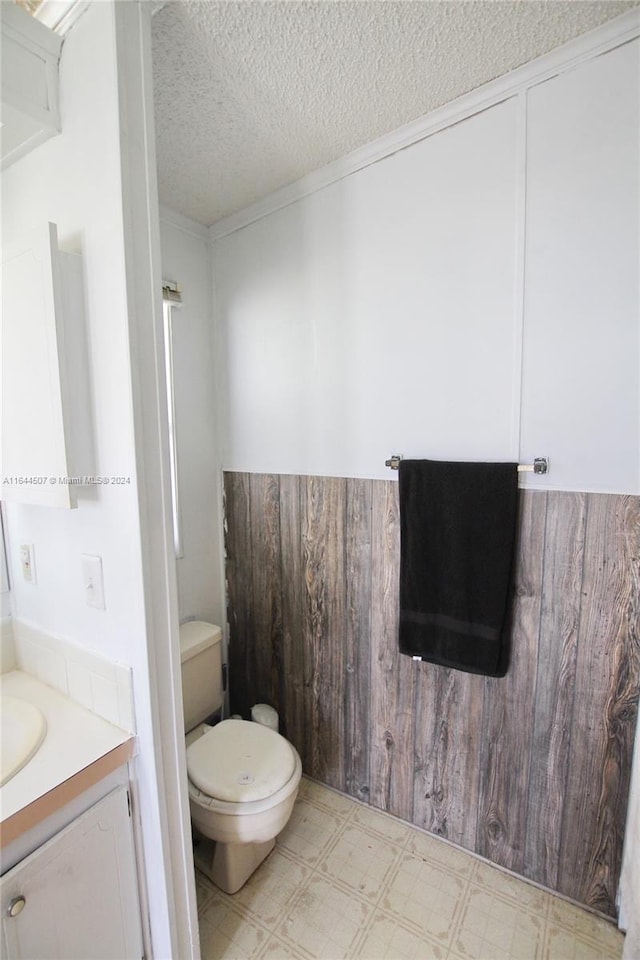 bathroom featuring tile patterned floors, a textured ceiling, vanity, and toilet